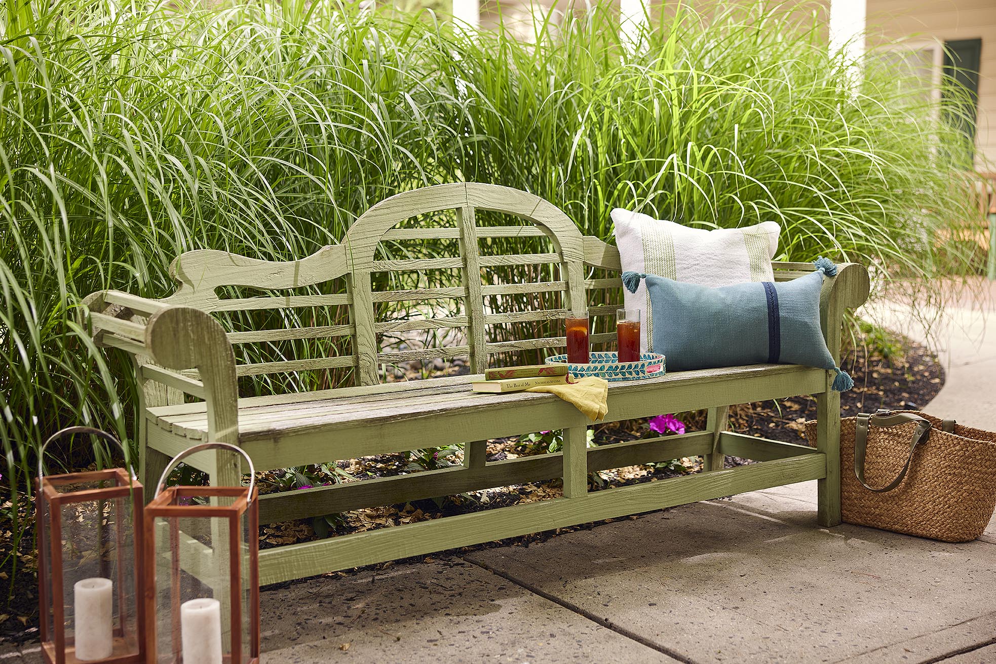 A bench in the garden with iced team, books and pillows