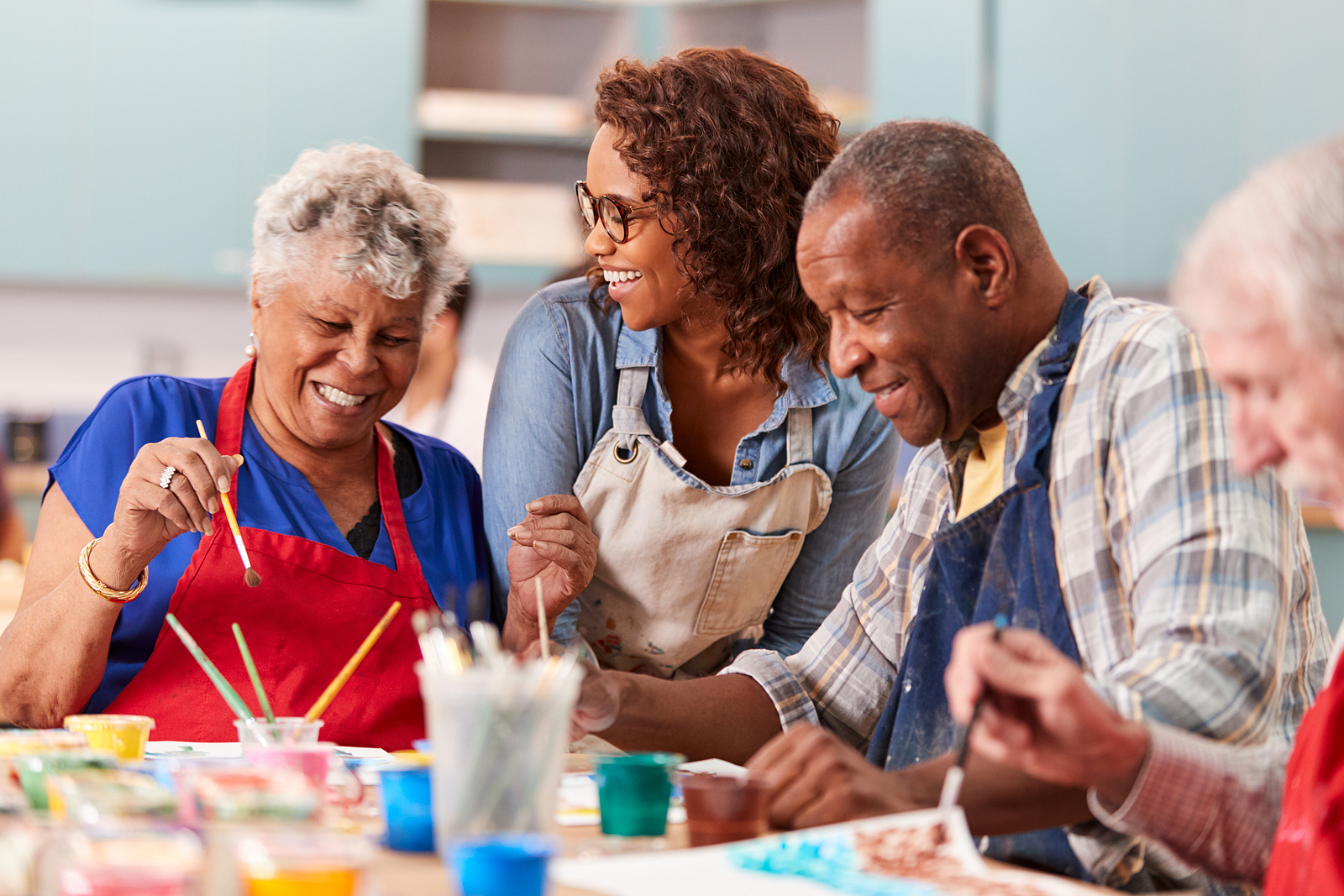 Group Of Retired Seniors Attending Art Class In Community Centre With Teacher