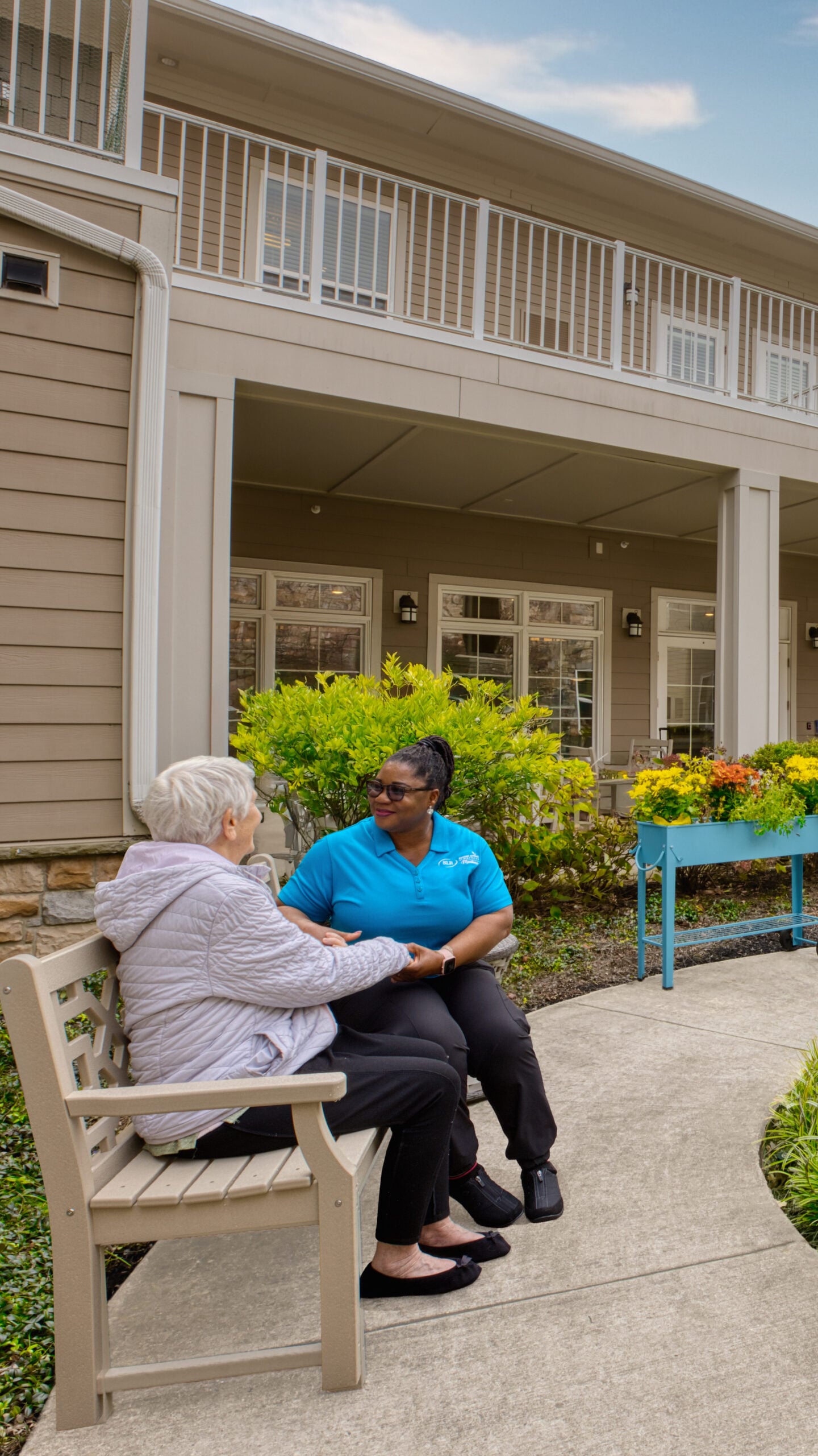 Resident and staff chatting in the Compass Courtyard