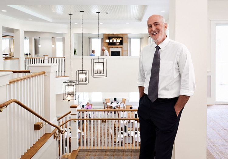 Michael Stoller in bright senior living community lobby