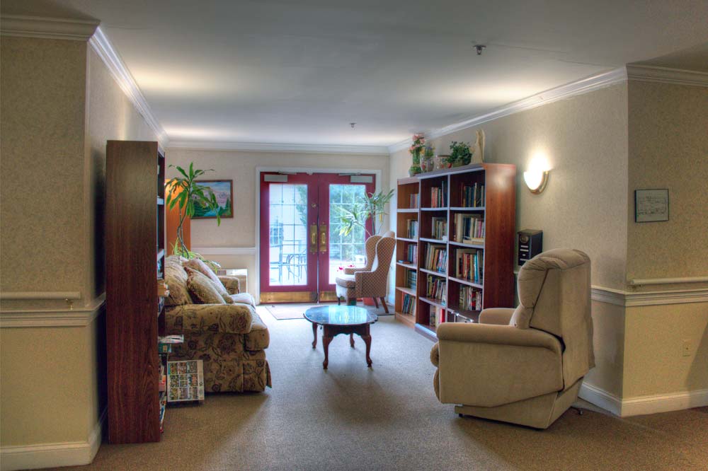 Sitting area with bookshelves and doors leading to garden area